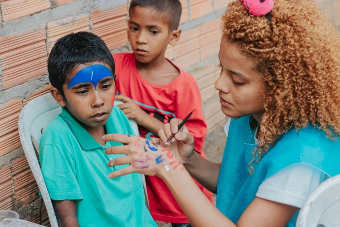 woman in blue shirt beside boy in teal crew neck t-shirt